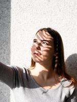 Retrato de una bella mujer joven con un patrón de sombras en la cara y el cuerpo en forma de hoja de palma foto