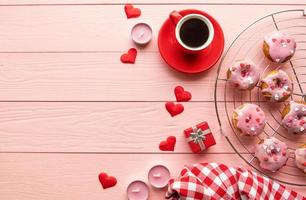 Valentines day brackfast with coffe and donuts isolated on pink wooden background photo