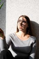 Portrait of a beautiful young woman with a shadow pattern on the face and body in the form of palm leaf photo