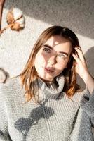 Portrait of a beautiful young woman with a shadow pattern on the face and body in the form of cotton photo