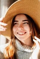 Portrait of a beautiful young woman in a straw hat with a shadow pattern on the face and body photo