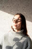 Portrait of a beautiful young woman with a shadow pattern on the face and body in the form of cotton photo