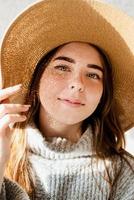 Retrato de una bella mujer joven con un sombrero de paja con un patrón de sombra en la cara y el cuerpo foto