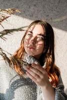 Portrait of a beautiful young woman with a shadow pattern on the face and body in the form of flowers photo