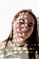 Portrait of a beautiful young woman with a shadow pattern on the face and body photo