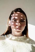 Portrait of a beautiful young woman with a shadow pattern on the face and body photo