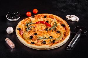 sabrosa pizza caliente fresca sobre un fondo oscuro. pizza, comida, vegetales, setas foto