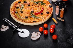 sabrosa pizza caliente fresca sobre un fondo oscuro. pizza, comida, vegetales, setas foto