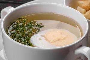 Sopa de fideos asiáticos, ramen con pollo, verduras y huevo en un tazón blanco foto