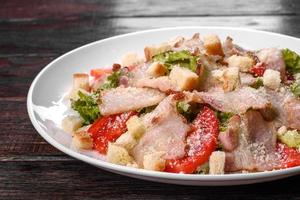 Delicious fresh salad with bacon and tomatoes with spices and greens photo