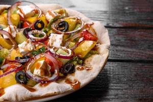 Tasty fresh Greek salad on a pita cooked for a festive table photo