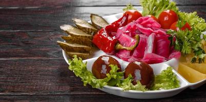 Delicious spicy pickles cut on a serving plate photo