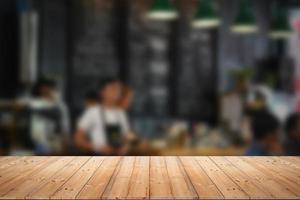 Wood table top with blur of people in coffee shop or cafe, restaurant background