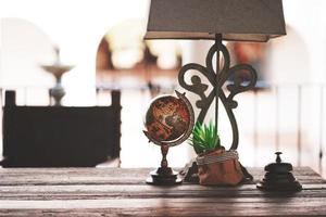 Lámparas y mapa del mundo colocados sobre la vieja mesa de madera. foto
