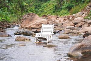 silla de playa de madera blanca en el río foto