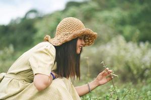 Beautiful Asian woman looking at flowers on the ground photo