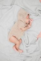 Adorable newborn baby peacefully sleeping on a white blanket