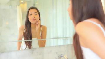 Young asian woman check her face on mirror video