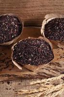 Riceberry rice in wooden cup on wooden tray, riceberry rice in kitchen background photo