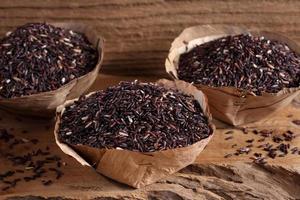 Riceberry rice in wooden cup on wooden tray, riceberry rice in kitchen background photo