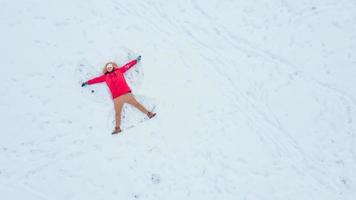 vista superior aérea del hombre haciendo ángel de nieve foto