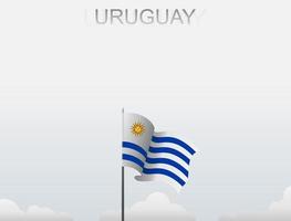 la bandera de uruguay ondea en un poste alto bajo el cielo blanco vector