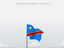 The Democratic Republic of The Congo flag is flying on a pole that stands tall under the white sky vector