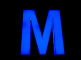 Blue neon letter M photo