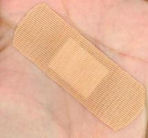 A medical self adhesive bandage on hand photo