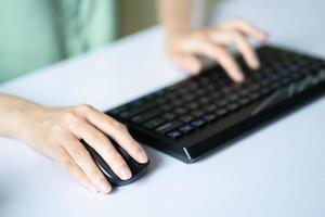 Asian woman using mouse and keyboard to work photo