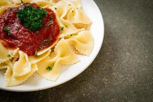 farfalle pasta in tomato sauce with parsley photo