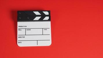 Clapperboard or movie slate. it use in video production ,film, cinema industry on red background. photo