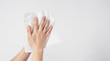 La mano está limpiando un pañuelo de papel sobre fondo blanco. foto