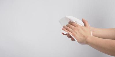 La mano está limpiando un pañuelo de papel sobre fondo blanco. foto