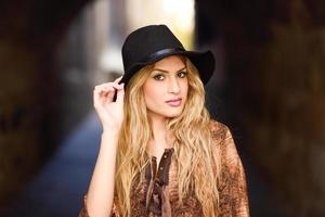 Beautiful young woman with curly hair wearing hat photo