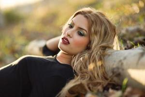 Relaxed girl lying on the field with long curly hair. photo