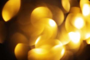 Defocus light sparkles of gold color as a background for designers photo