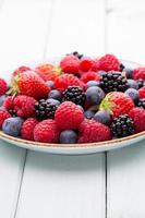 Fresh berry salad on blue dishes photo