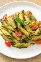 penne pasta with pesto sauce and tomatoes photo