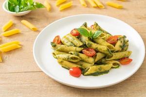 penne pasta with pesto sauce and tomatoes photo