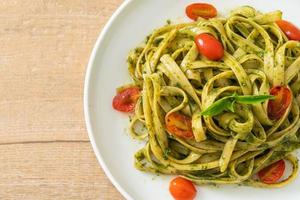 fettuccine spaghetti pasta with pesto sauce and tomatoes photo