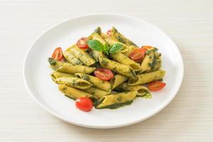 penne pasta with pesto sauce and tomatoes photo