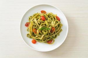 fettuccine spaghetti pasta with pesto sauce and tomatoes photo