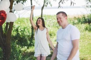 Happy and young pregnant couple hugging in nature. Romantic moments photo