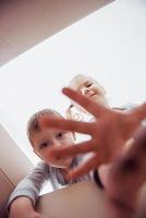 Two a little kids boy and girl opening a cardboard box and climbing in the middle of it. Children have fun photo