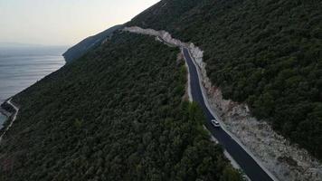 concetto di viaggio in auto vista aerea della strada di montagna vicino al mare sull'isola di lefkada video