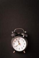 Black retro alarm clock isolated on black background with copy space photo