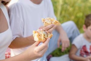 Pareja joven haciendo un picnic en el campo de girasol al atardecer foto