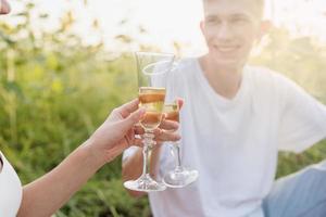 Pareja joven haciendo un picnic en el campo de girasol al atardecer foto