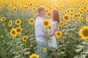 hermosa pareja divirtiéndose en campos de girasoles foto